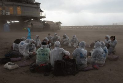 People sitting in a circle before a digger